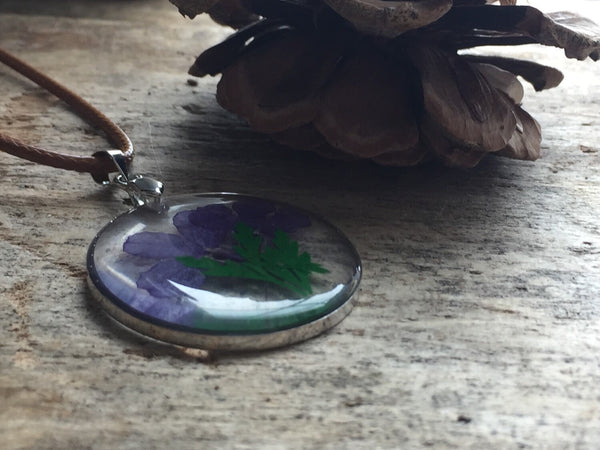 Collier breloque de résine transparente avec fleurs sur corde de cuir brune Comme un ange