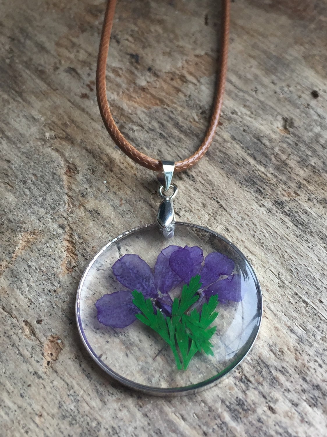 Collier breloque de résine transparente avec fleurs sur corde de cuir brune