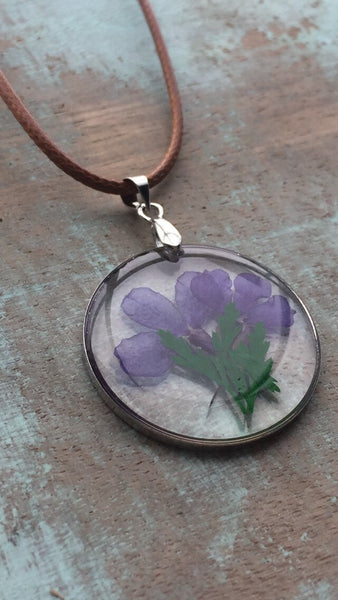 Collier breloque de résine transparente avec fleurs sur corde de cuir brune Comme un ange
