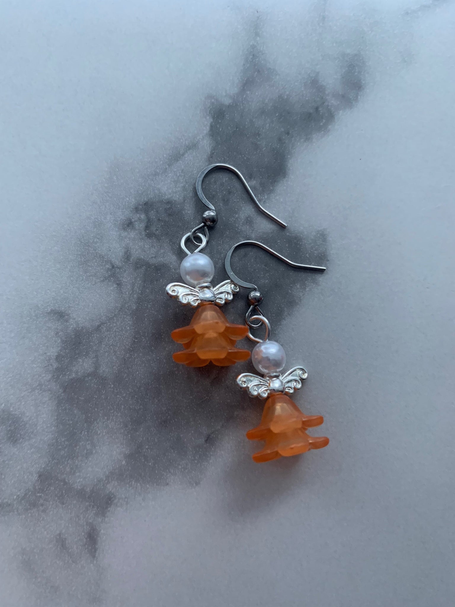 Boucles d’oreilles breloque ange tête de perle robe orange Comme un ange