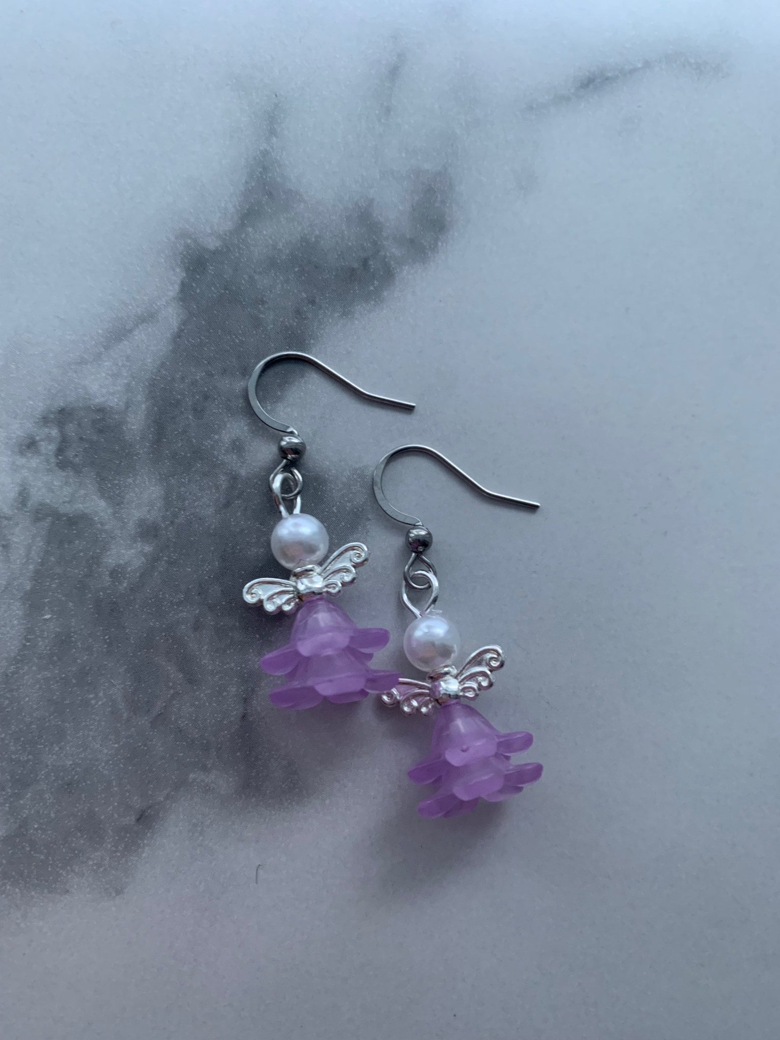 Boucles d’oreilles breloque ange tête de perle robe mauve Comme un ange