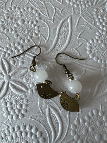 Boucles d’oreilles breloque oiseau bronze et bille de verre blanche Comme un ange