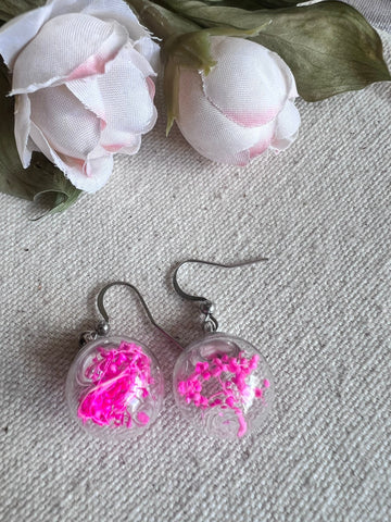 Boucles oreilles fleurs fushia dans une bulle de verre